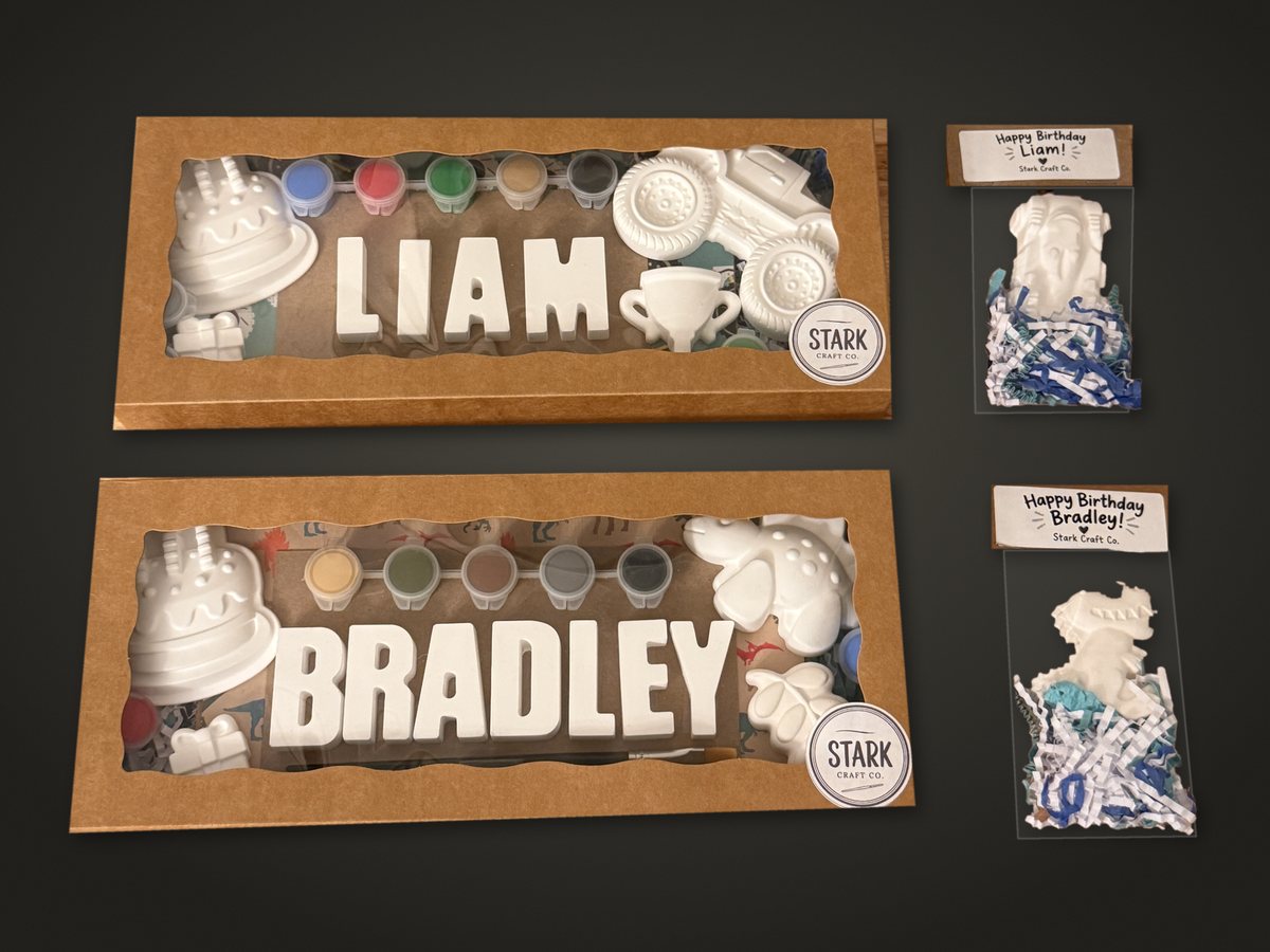 Two Personalized Birthday Kits spelling LIAM and BRADLEY in kraft window boxes, each with a cake piece, themed pieces, paints and a brush, beside two Happy Birthday favor bags.